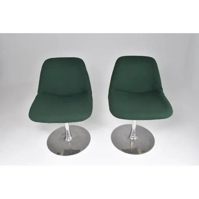 A pair of swivel chairs by Robin Day, dating to the 1960s. The design is defined by molded shell seats, central aluminum...