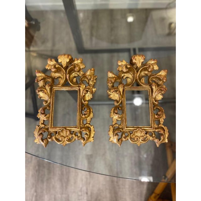 A pair of handcrafted rectangular frames made of carved, gilded wood, reminiscent of the italian baroque style or the...