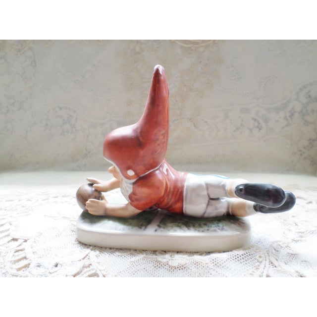 This is a Vintage West German Goebel Co Boy Figurine "Tommy" who is a football Player that is 7" long and 5.5" tall and...