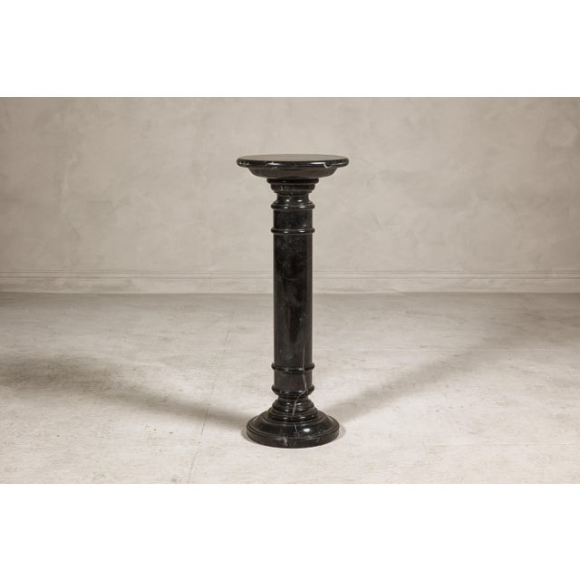A vintage black marble column shaped pedestal with white veining and stepped base. This vintage black marble column-shaped...