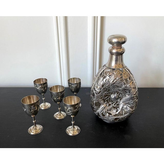 A set of Chinese Export silver drinking set consists of a pinch bottle and five cordials circa 1910s-1920s. Featuring...