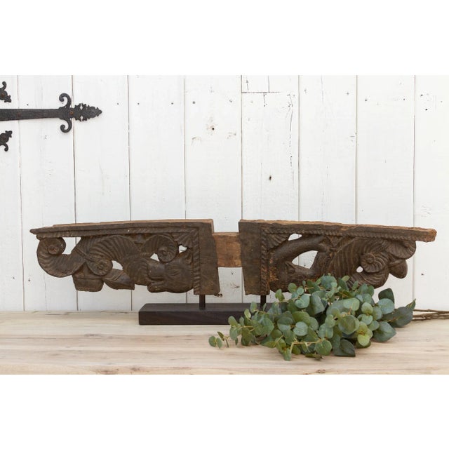 A beautiful architectural corbel from Nepal, featuring an elaborate carved design of a dragon head on one side and a fish...