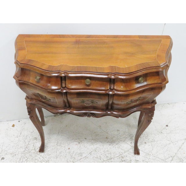 Italian burlwood 6 drawer commode made by Borghesani, serpentine and bombay form with carved legs and skirt, brass hardware.