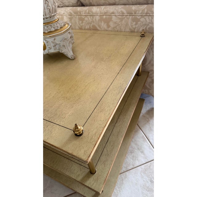 Square three-tier side table featuring a light natural wood finish with a warm antiqued wash, inset top detailing, and...