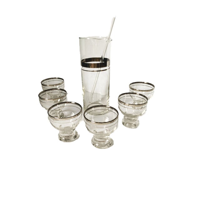 This vintage 1950s, Dorothy Thorpe style, platinum band atomic cocktail pitcher set is a stunning example of mid-century...