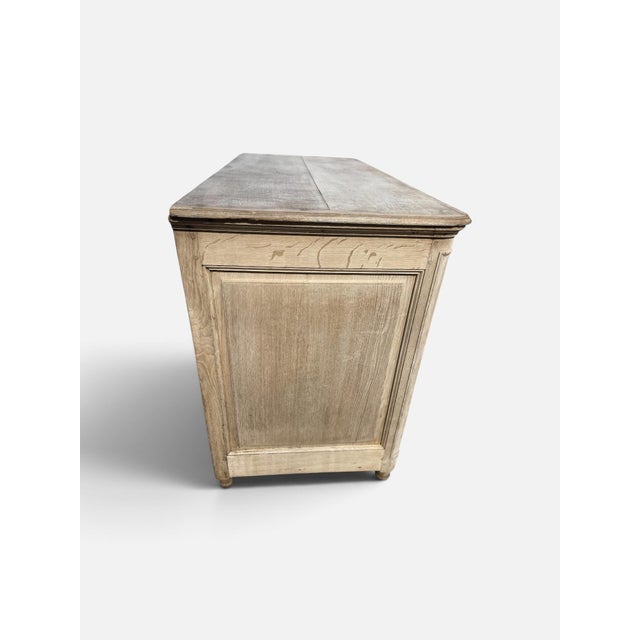 The oak 3-drawer chest with mouldings around the drawer fronts, plain panelled sides and brass handles and key escutcheons.