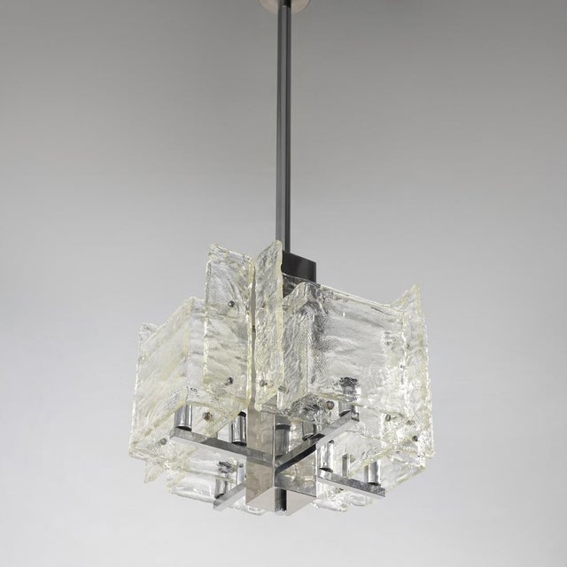 An Italian chandelier from the 1970s characterised by a geometric chrome-plated metal structure surrounded by a...