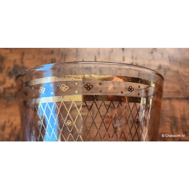 This is a very nice looking Mid Century Modern vintage 1950s glass ice bucket with gold decorations. Some heavy wearing to...