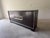 Elegant Ethan Allen Eastview sideboard featuring a rich, dark wood finish accented by distinctive brass-tone geometric...