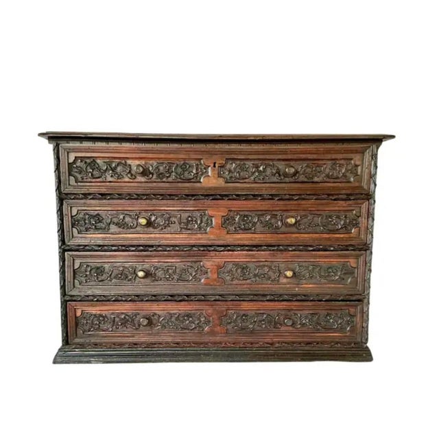 Early 18th Century Italian Carved Walnut Commode. Commode features four deep drawers adorned with elaborately carved...