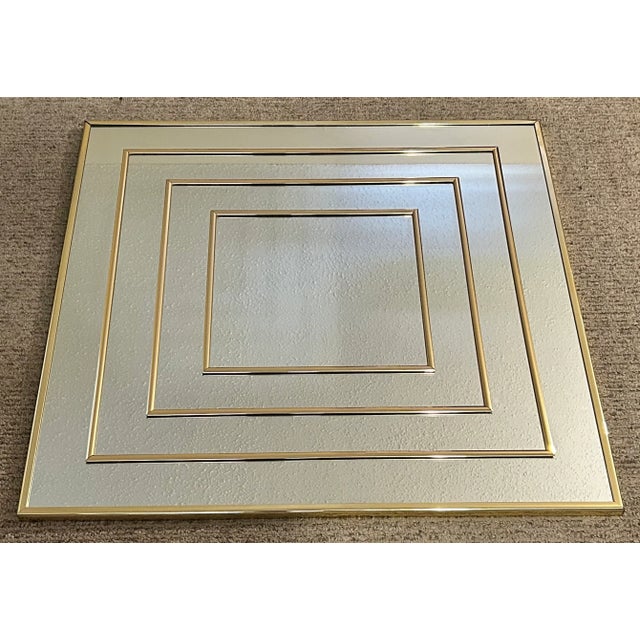 Up for sale is a Vintage 1980’s American Syroco Postmodern Brass Style Metal/Glass Concentric Squares Wall Mirror! It...