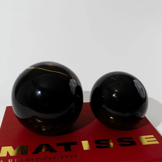 Vintage ceramic spheres featuring a lustrous black glaze with striking gold marbling throughout. The set includes one...