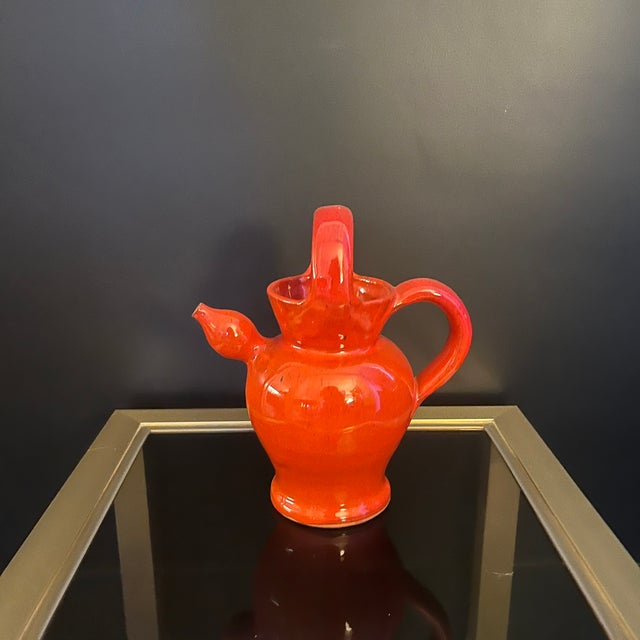 Charming glazed red/orange ceramic water pitcher, signed PR on the reverse for Pierre Rinaudo (1930-2005), a ceramist from...