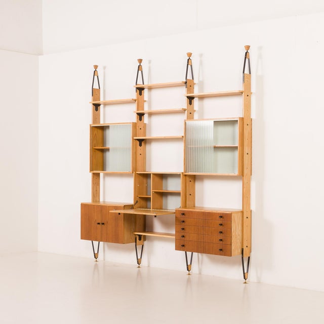 This unique czechoslovakian floor-to-ceiling mid-century wall unit crafted in the 1960s perfectly blends functionality...