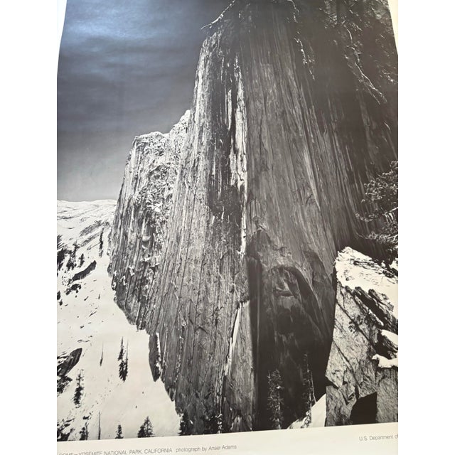 The image is a poster featuring Ansel Adams' iconic photograph, "Monolith, the Face of Half Dome" Printed in 1968