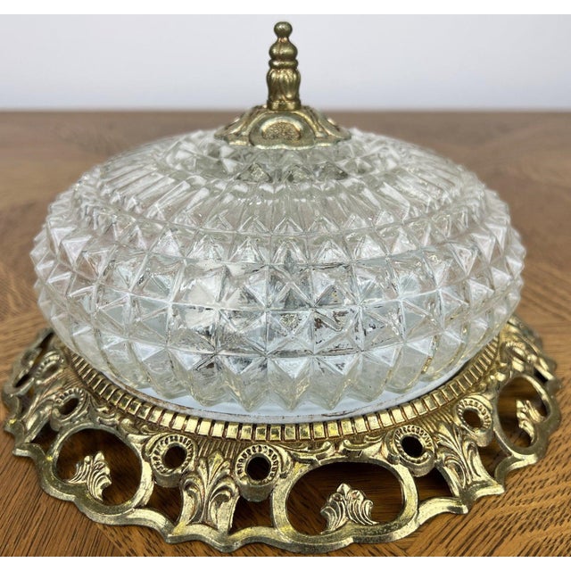 A charming Vintage French ceiling lamp featuring an elegant cut glass shade with geometric detailing and an ornate...