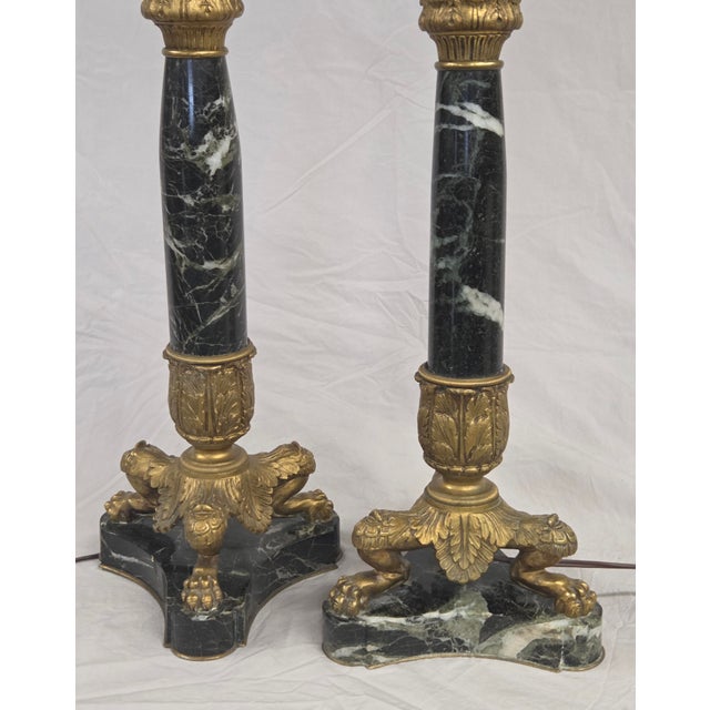 A beautiful vintage circa 1950s French empire neoclassical style marble and gilt bronze pair of table lamps. The stunning...
