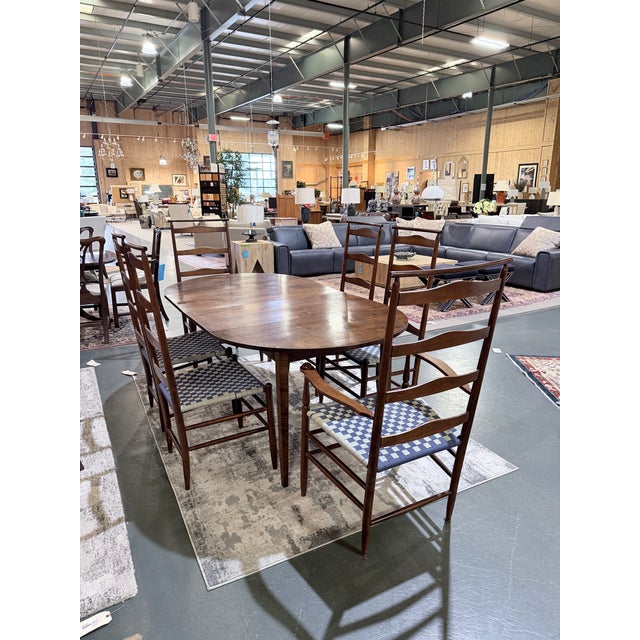 A distinguished example of American country craftsmanship, this vintage Asher Benjamin dining set showcases the warmth and...