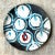 This vintage Boho-style studio pottery charger features a vibrant hand-painted design, showcasing abstract circular...