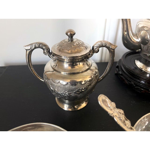 A Chinese export sterling silver tea set comprised of 13 pieces including tea pot, sugar, creamer, four tea bowls and six...