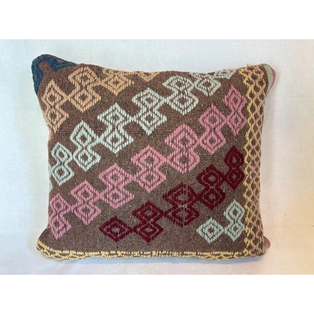 This beautiful pillow blue, yellow, pink, tan and red diamonds.