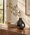A sculptural black vase with a rounded teardrop body, tapered shoulders, and a gently flared rim. Its smooth, highly...