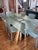 Custom modern dining room set consisting of 3/4 inch thick glass table rests on top of a simple, yet elegant, black steel...