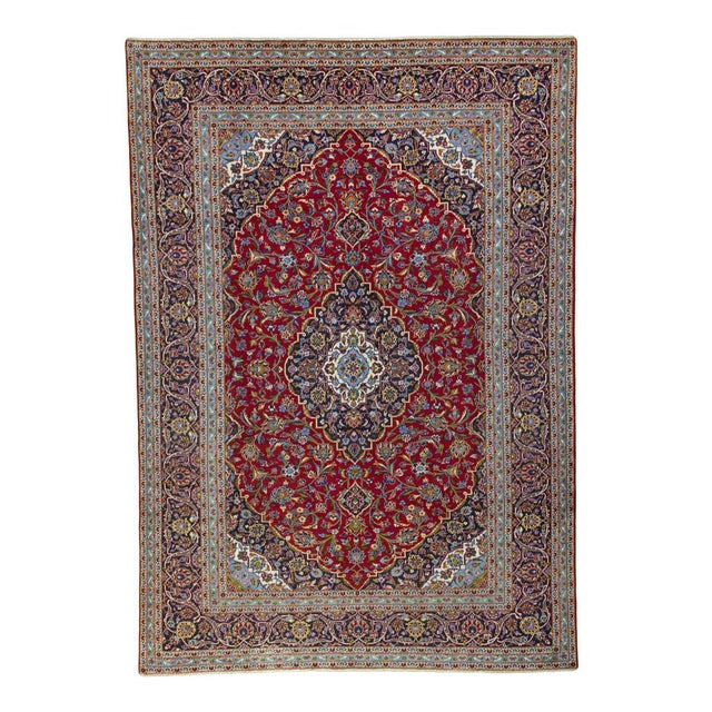 An impressive classic from the renowned Kashan knotting region: This artfully crafted rug impresses with its vibrant red...