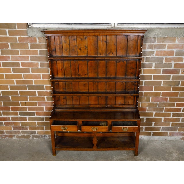 A Welsh cupboard from the 19th century with three drawers and open shelves. This 19th-century Welsh cupboard embodies the...