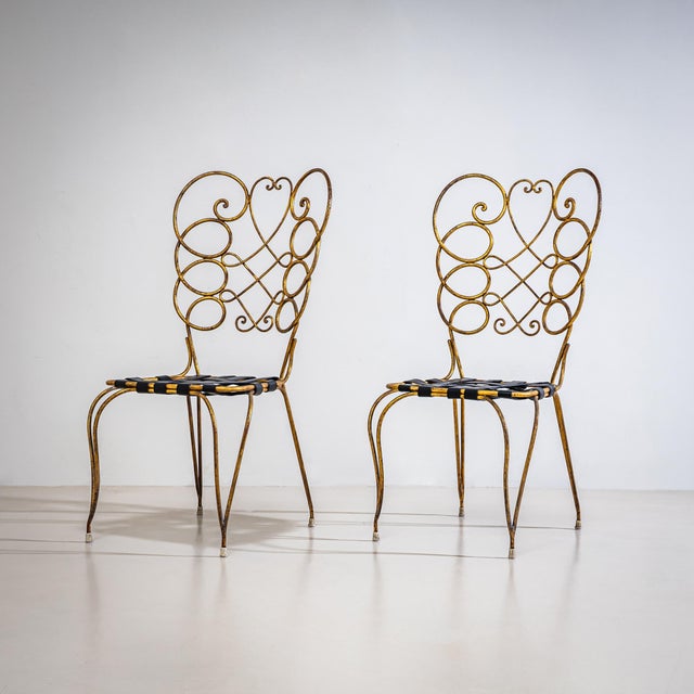Pair of Italian side chairs crafted from bent tubular metal with a gilt-patinated finish. The chairs are distinguished by...