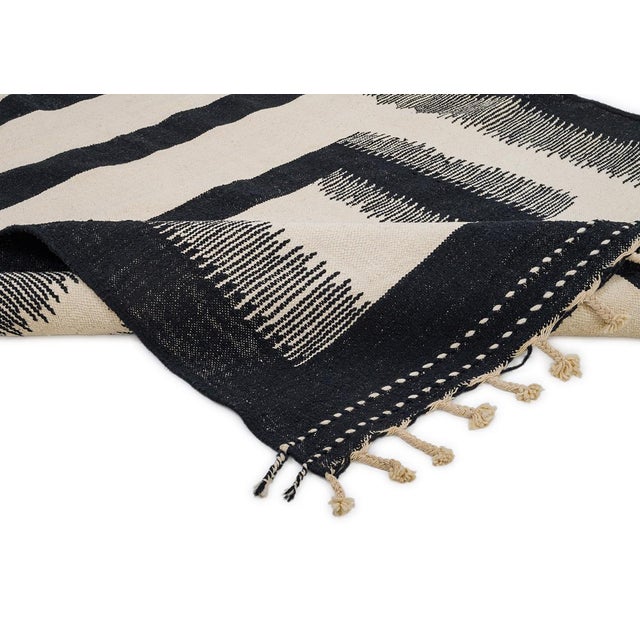 Bold handwoven wool rug featuring geometric squares in Midnight Black on an Ivory backdrop. The striking contrast and...