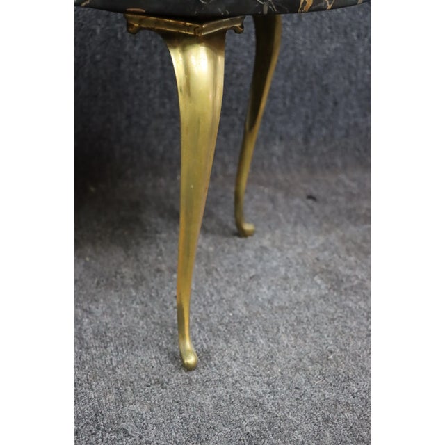 Mid Century cocktail tables with gilded legs and black marble tops.