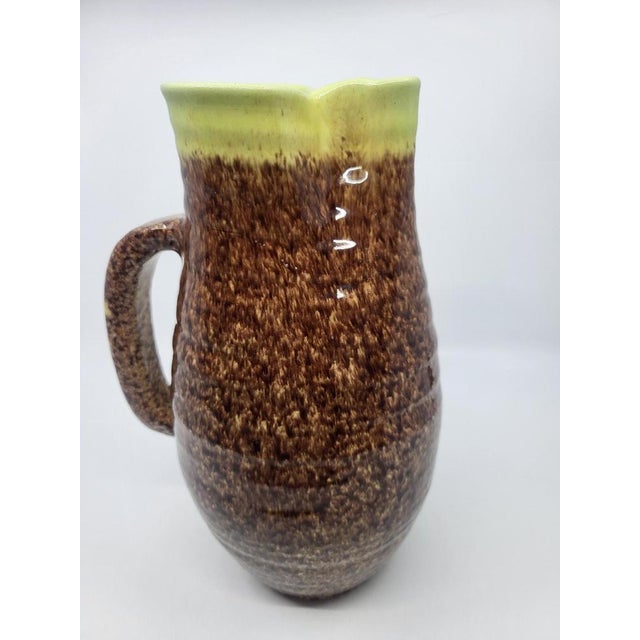 Accolay pottery pitcher in brown and yellow ceramic, France, 1970. It is 27 cm tall, with a unique design thanks to its...
