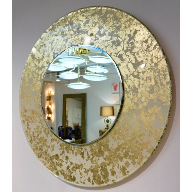 A modern Made in Italy round mirror, entirely handcrafted in glass, of high quality execution: the thick glass frame with...