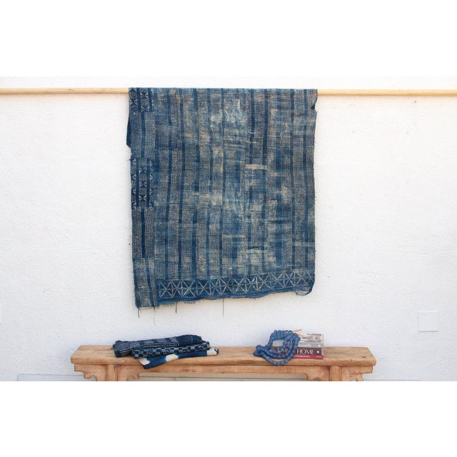 A masterwork of Malian textile heritage featuring deep indigo saturation and symbolic geometric motifs. Originating from...
