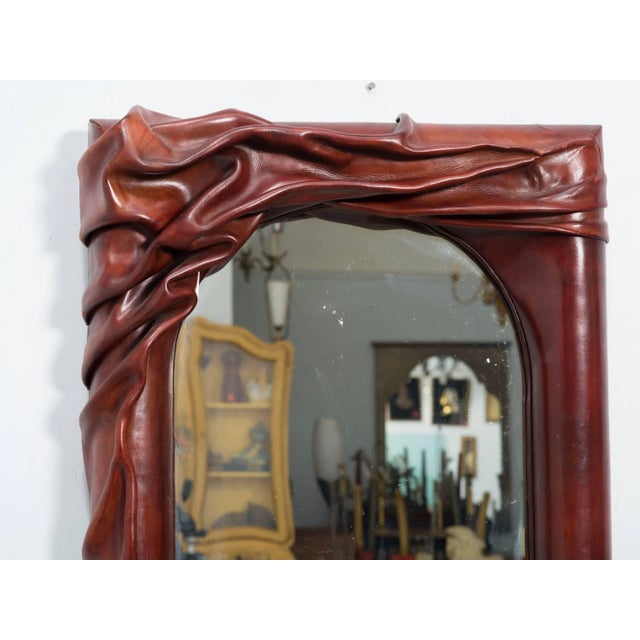 Sculptural leather wall mirror.
