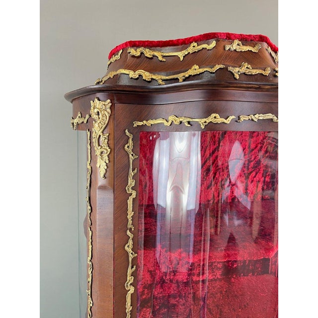 An elegant louis xv style display cabinet dating from the 19th century, crafted from marquetry wood and adorned with rich,...