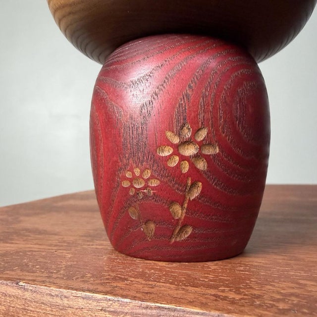 A refined, creative kokeshi with a beautiful balance of dark and warm-toned wood. The face is rendered in a minimal style,...