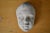 The piece is a child's face in plaster. The surface has a patina and shows signs of age. The piece is dated 1924 and...