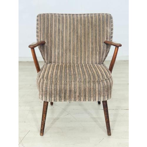 Two stylish vintage armchairs from the 1960s. These armchairs impress with their classic design, featuring upholstered...