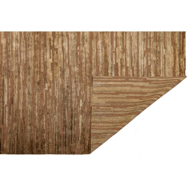 This beautiful modern Soumak hand-knotted Jute rug has a golden-tan field. It features brown accents in a gorgeous all-...