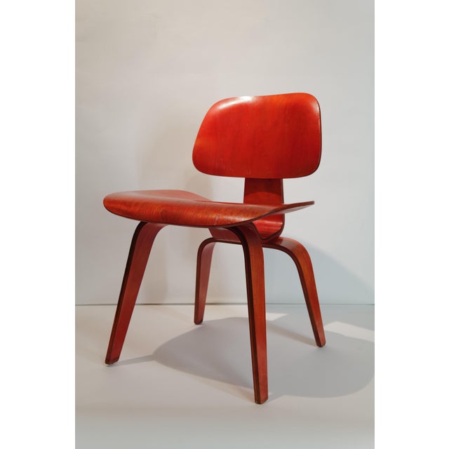 Wonderful red aniline dyed DCW by Charles and Ray Eames. Early 5-2-4 screw pattern. Not labeled.