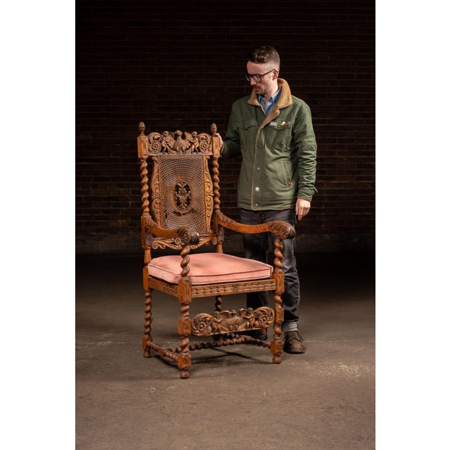 19th century Heavily carved wooden armchair with barley twist supports, pierced crest rail, and carved figural decoration...
