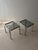 Chrome, smoked glass, and a construction in which virtually no right angles can be found. This set of two side tables was...