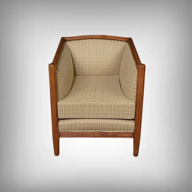 This armchair embodies the understated, geometric elegance of the 1930s Art Deco style. Its stained beech frame, with its...