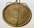 Round brass-tone serving tray with a raised floral border, ornate central decoration, and three curved supports meeting...