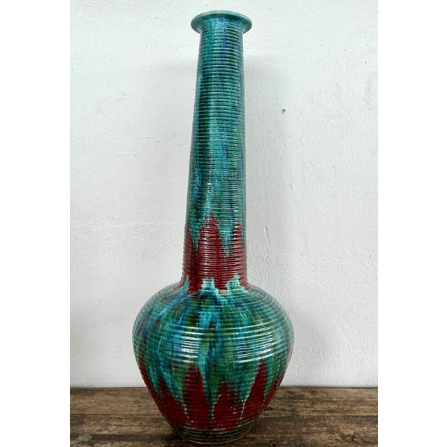 Standing 38 inches tall, this vintage ceramic vase makes a dramatic sculptural statement with a bulbous base, long slender...