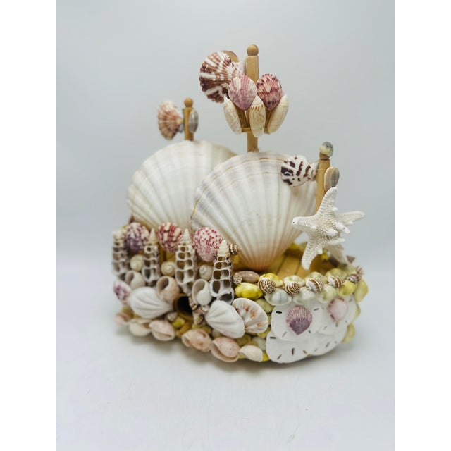 This is a beautifully crafted vintage shell-adorned birdhouse with an intricate nautical and coastal design. The structure...