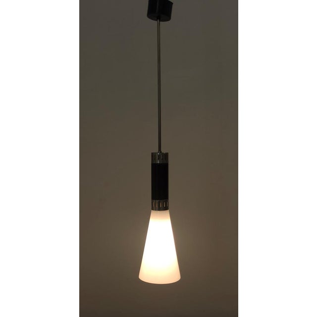 Made in Italy, 1960s. It is in opaline glass, chrome plated brass and black varnished aluminum. This pendant is a vintage...