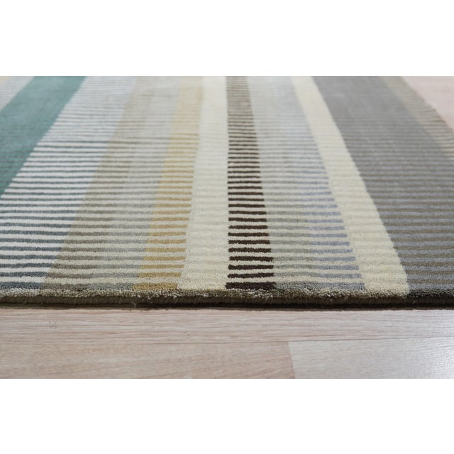 Zinnia Striped Green Handmade Wool Rug, Country of Origin: India. This exceptional piece showcases the refined skill...